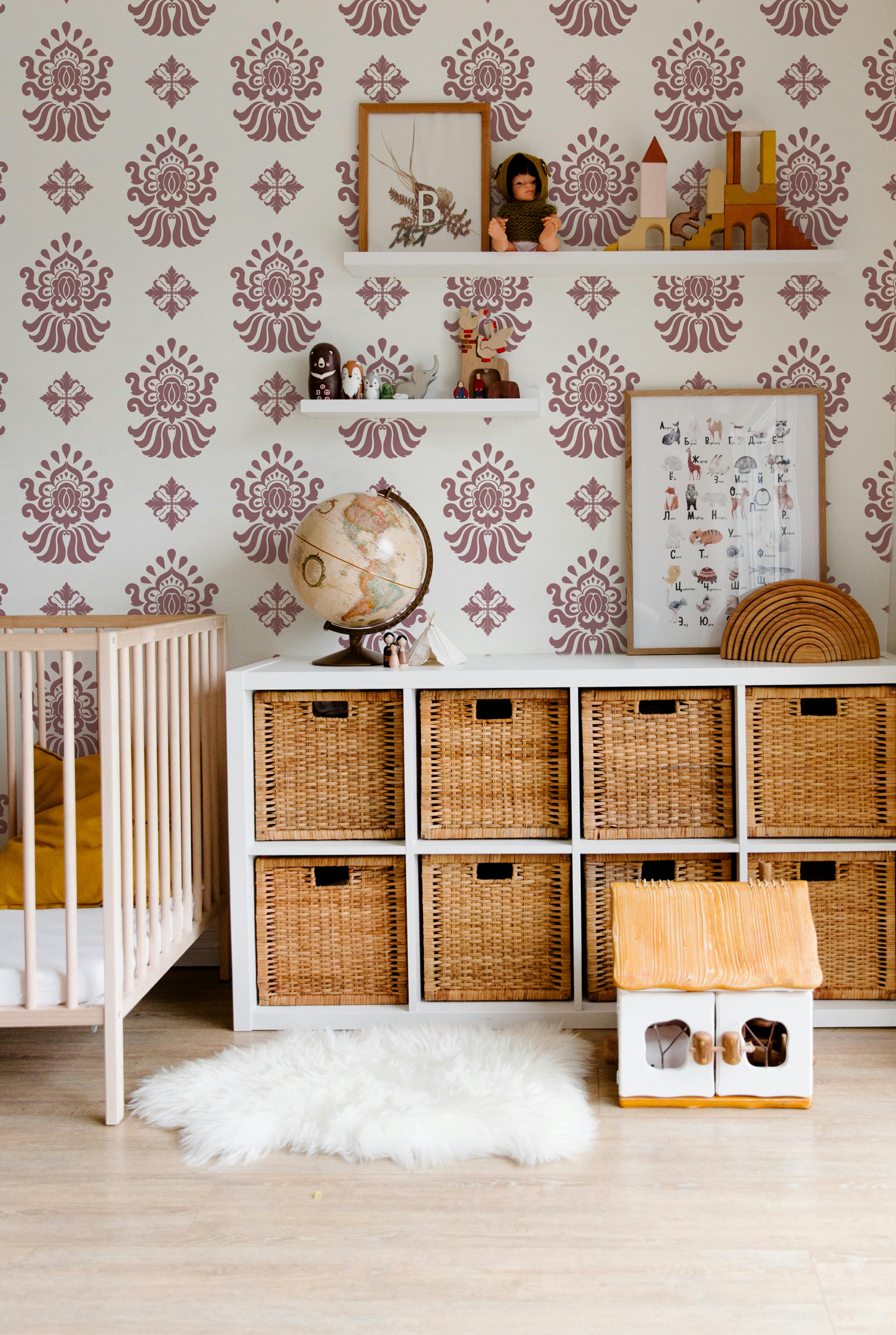 Dusty pink and cream ornamental wallpaper styled in a warm nursery and kids room