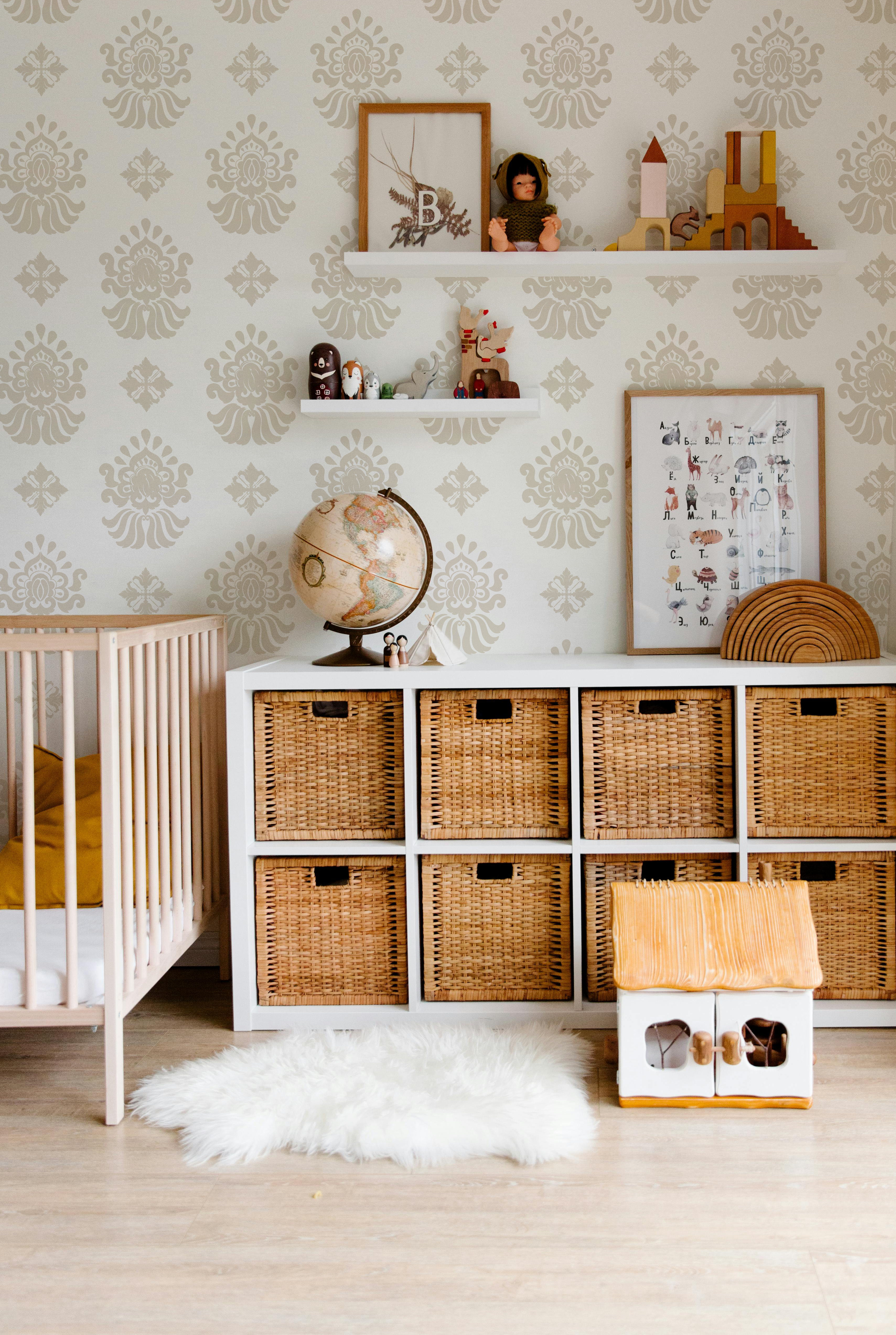 Beige and cream ornamental wallpaper styled in a neutral nursery and kids room