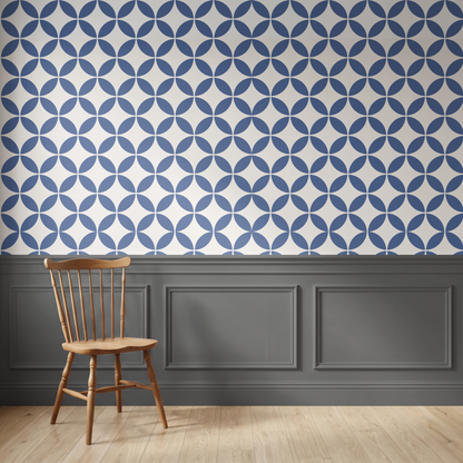 Navy blue geometric wallpaper above traditional wall panelling with a wooden chair