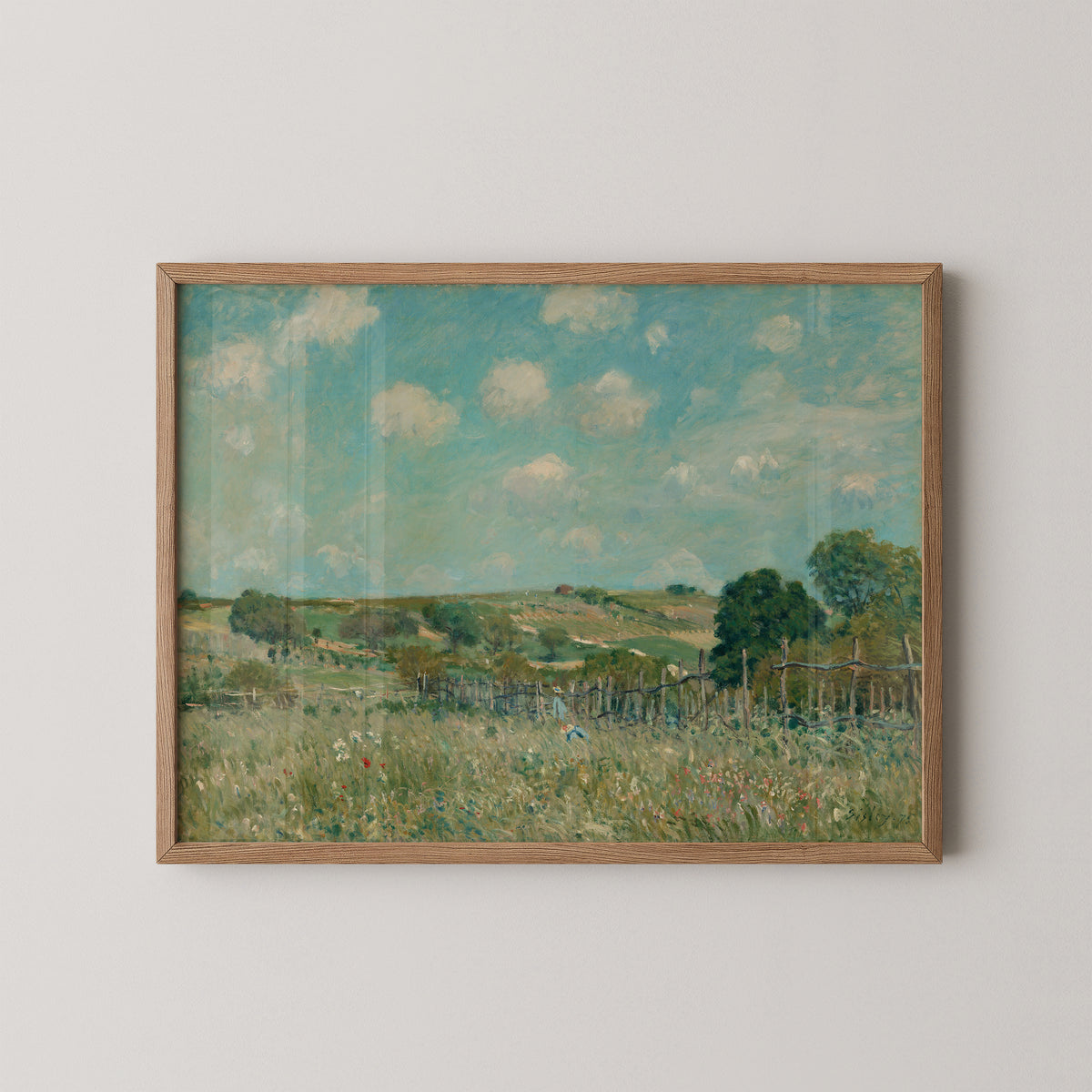 Natural wood-framed Sisley Meadow print, with green grasses and a rustic fence leading into the distance