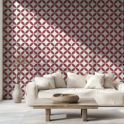 Burgundy retro geometric wallpaper with interlocking circles behind a white sofa