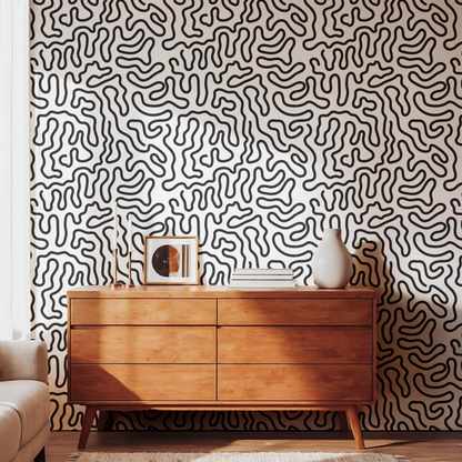 Black and cream abstract wallpaper with organic squiggle lines in a modern living room