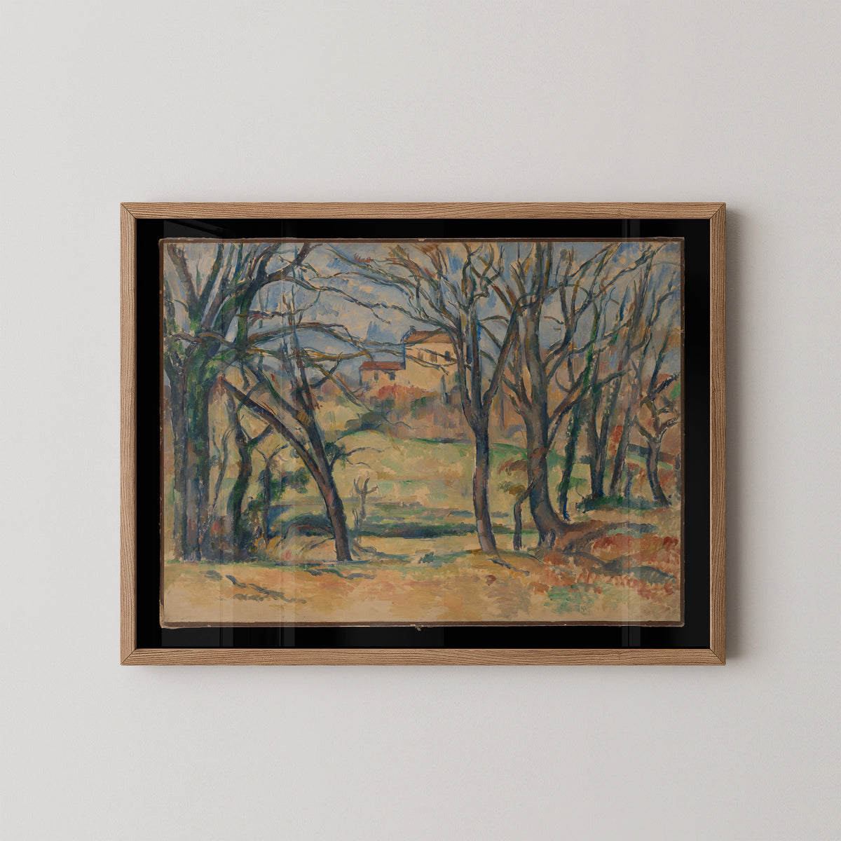 Cézanne countryside art print with terracotta roofs behind branching trees, shown in a natural wood frame