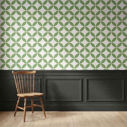 Green geometric wallpaper above dark traditional wall panelling with a wooden chair