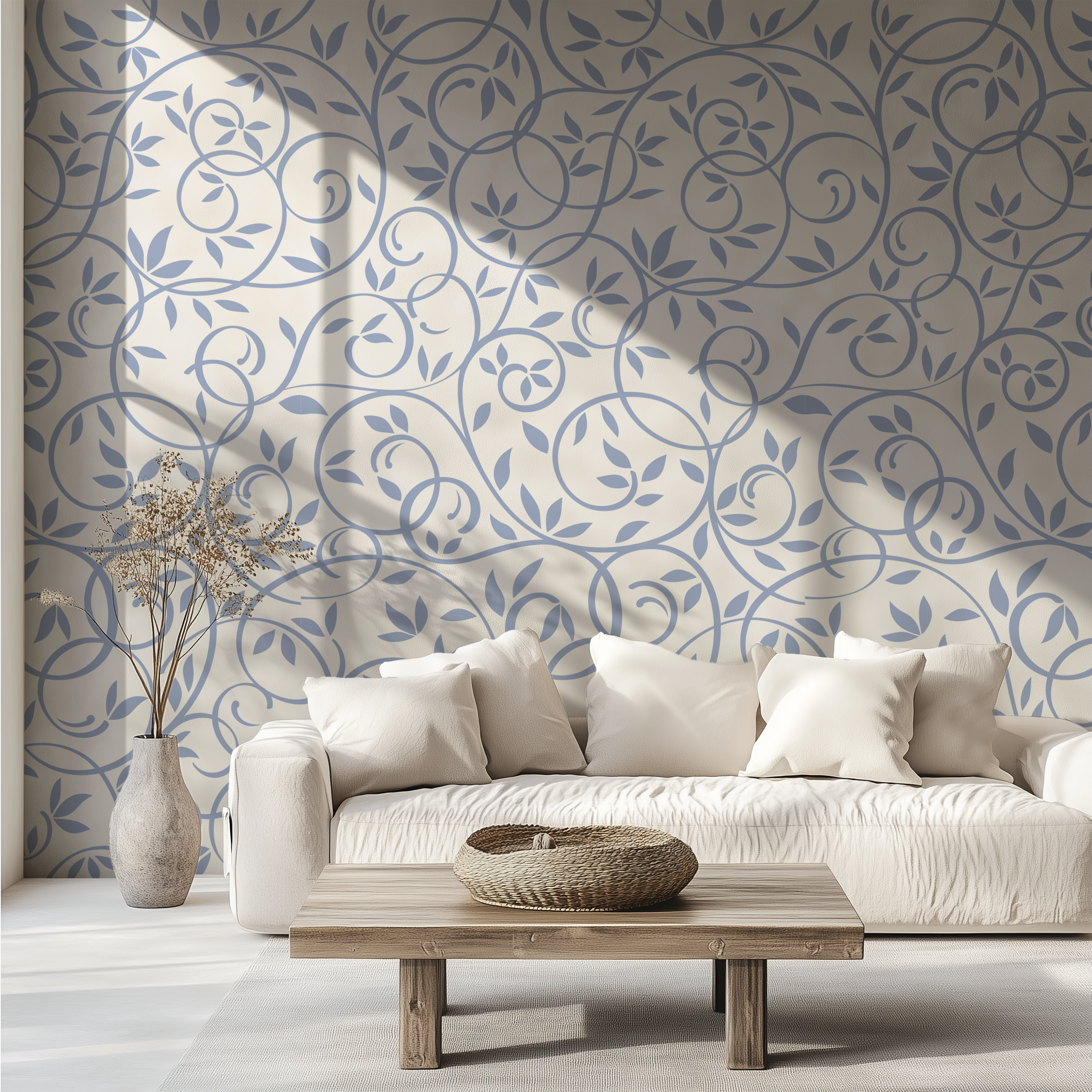 Dusty blue leaf and vine wallpaper styled behind a neutral sofa