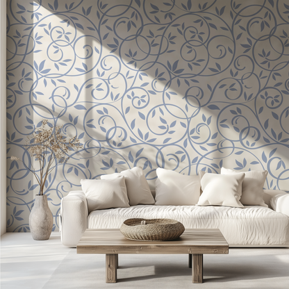 Dusty blue leaf and vine wallpaper styled behind a neutral sofa