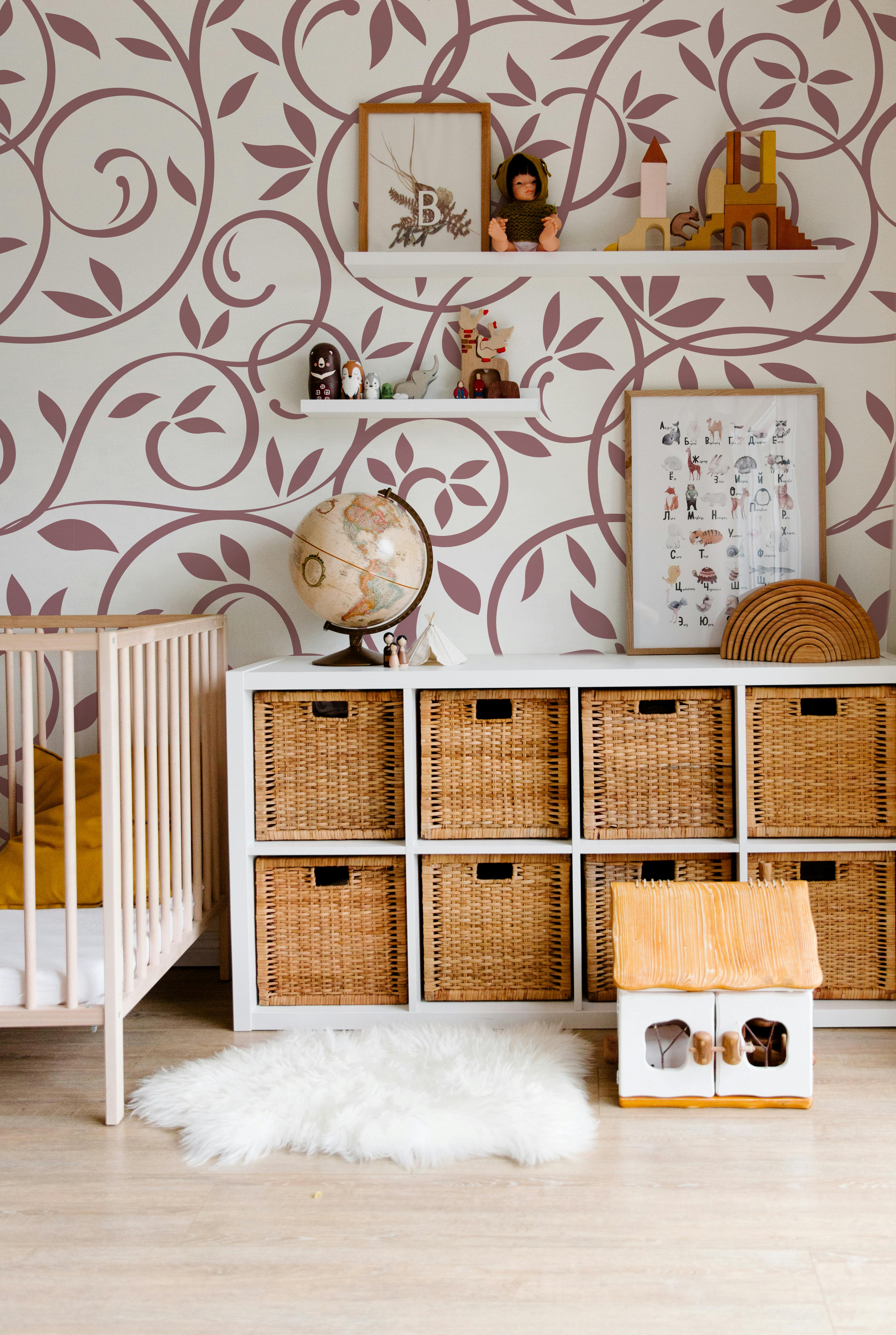 Dusty rose botanical floral wallpaper styled in a soft neutral nursery