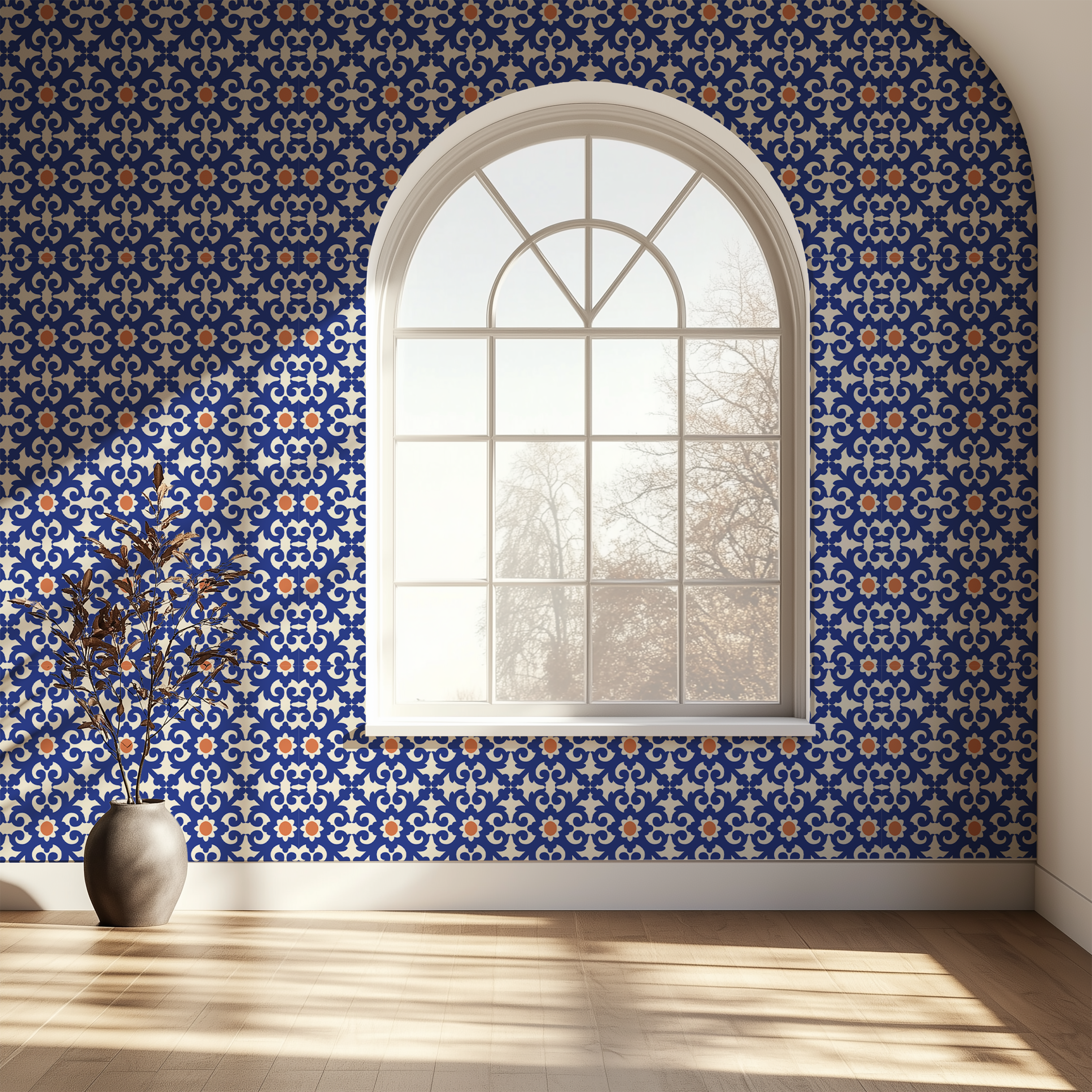 A room interior with floral wallpaper in soft pink, beige, and mint green tones, featuring a large arched window and sunlight streaming across a light wood floor. A gray vase with dried branches sits on the left.